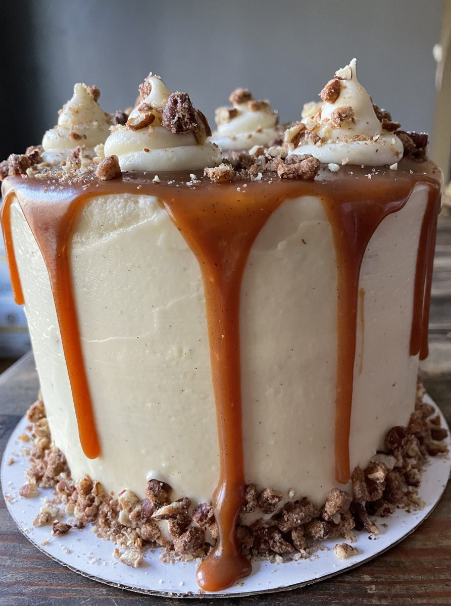 Layer cake with cream cheese frosting, caramel drip and candied pecans